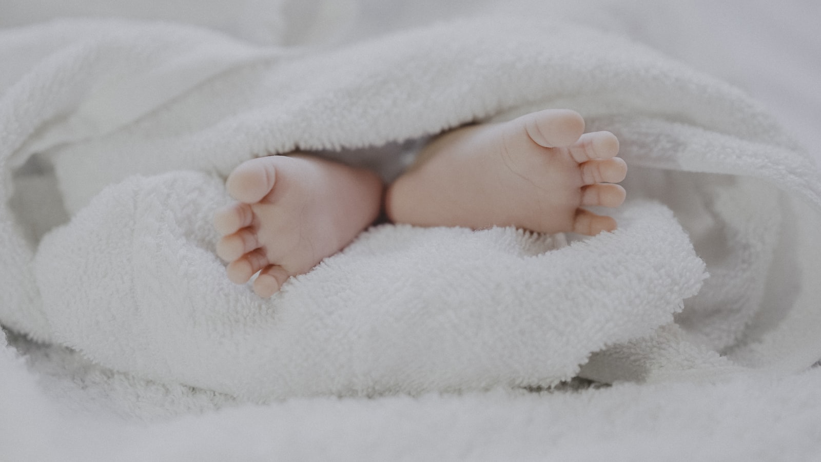 A newborn baby wrapped in a soft blanket resting peacefully